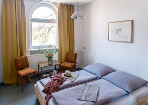 MünchebergGasthaus zur Ostbahn的一间卧室配有一张床、一张桌子和一个窗户。