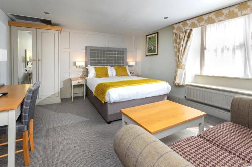 斯基普顿长毛羊宾馆的酒店客房带一张床、一张桌子和椅子