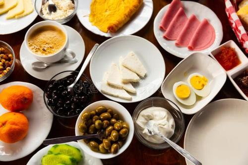 茨卡尔图博Andro's Guesthouse的桌上放满了鸡蛋和水果的盘子