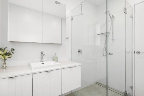 悉尼Urban Rest Neutral Bay Apartments的白色的浴室设有水槽和淋浴。