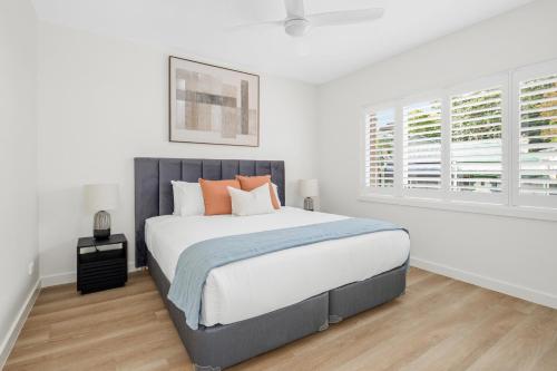 悉尼Urban Rest Neutral Bay Apartments的白色卧室配有带橙色枕头的大床