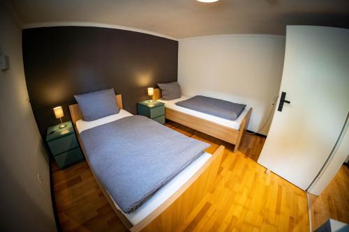 杜塞尔多夫Gemütliche 2-Zimmer Souterrain Wohnung的小房间设有两张床和两盏灯