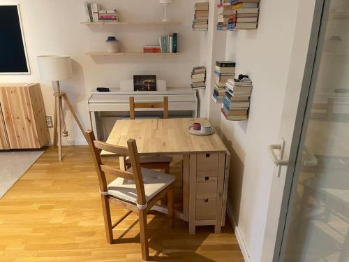 布伦瑞克Geschmackvoll eingerichtete Wohnung in Braunschweig的一张木桌和椅子,位于带书桌的房间里