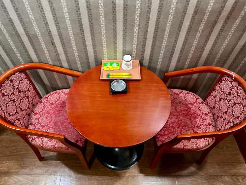 首尔Grace Motel的一张木桌,配有两把椅子和一本书