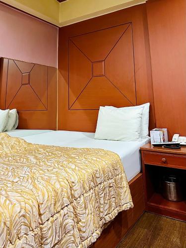 首尔Grace Motel的一间卧室配有一张带木制床头板的床