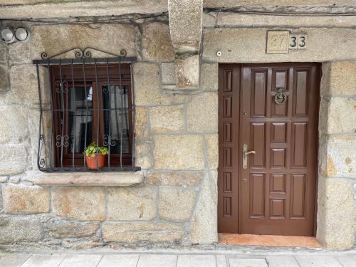 科尔库维翁A Casiña de Juan的一座石头建筑,设有棕色的门和窗户