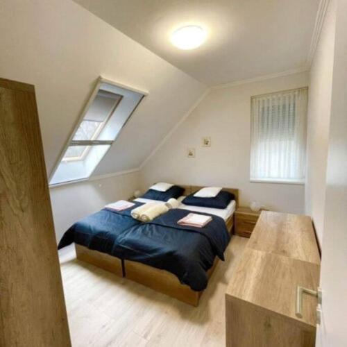 帕波LILIBORI apartman的一间卧室设有两张床和窗户。