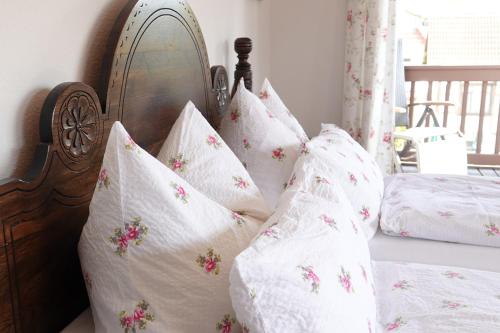 劳达-柯尼希斯霍芬阿德勒酒店的一张带白色枕头和木制床头板的床
