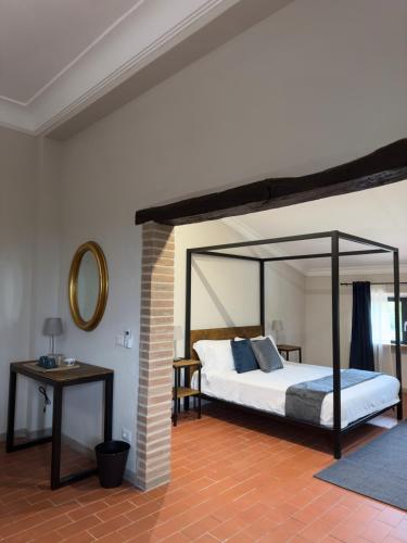 基安奇安诺泰尔梅Casa M Vineyard的一间卧室配有一张天蓬床和一张桌子