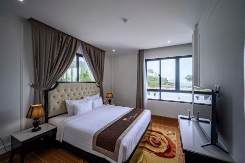 归仁Seaside Boutique Resort Quy Nhon的一间卧室设有一张大床和大窗户