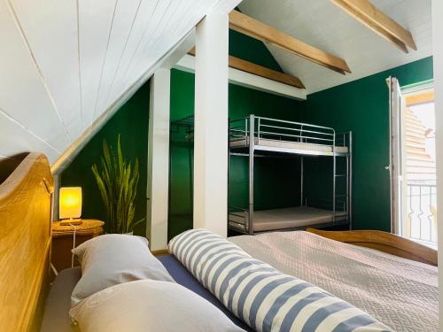 维尔纽斯米卡洛旅舍的一间带绿色墙壁和一张双层床的卧室
