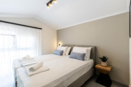 卡利维亚波里吉鲁Bianco Mare Studios-Apartments的一间卧室配有一张带白色床单和蓝色枕头的大床。