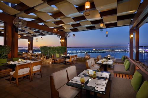 阿布扎比阿布扎比圣瑞吉酒店的一间设有桌椅的餐厅,享有美景。