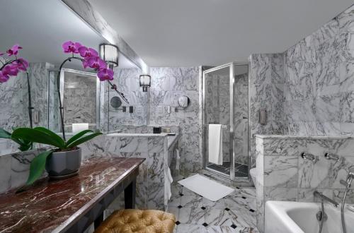 吉隆坡吉隆坡千禧大酒店的一间带大理石墙壁、浴缸和水槽的浴室