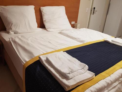 美因河畔法兰克福Hotel Emiliana am Bahnhof的一张带白色床单和毛巾的床