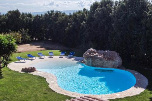 卡布拉斯Agriturismo Villa Gaia的一个带椅子的游泳池以及一座大型岩石