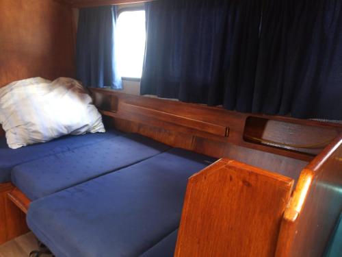 摩拉瓦河畔韦塞利Ubytování na námořní jachtě的一个小房间的一个床位,设有窗户