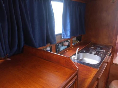 摩拉瓦河畔韦塞利Ubytování na námořní jachtě的一个带水槽和窗户的小厨房
