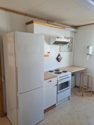贝勒沃格Berlevåg Motell AS的厨房配有白色冰箱和炉灶。