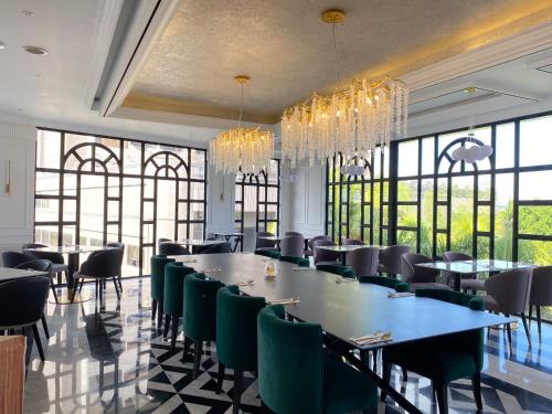 名古屋Grand Eska Hotel & Suites Batam的一间带长桌和椅子的用餐室