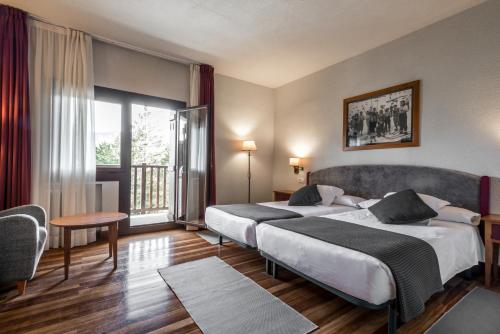 福米加尔Snö Hotel Formigal的酒店客房设有两张床和一个阳台。