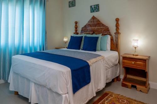 卢西Hamilton @ Oceanpointe a serene 2bed 2 bath Villa的一间卧室配有一张带蓝色枕头的大床
