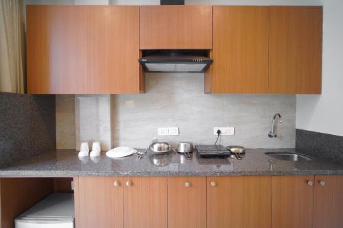 古尔冈Saltstayz Executive Studio Apartment的厨房配有木制橱柜和台面
