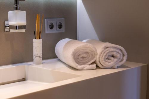 卢森堡Core Luxembourg City- Luxury Brands Street的浴室内一个柜台上的毛巾