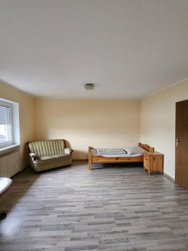 Töging am InnStadthostel的一间空房间,里面配有沙发和一张床
