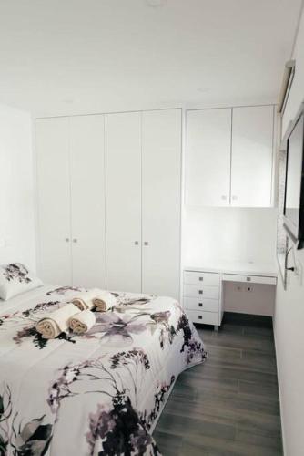 埃斯平霍Vale Do Mar House的白色卧室配有床和书桌