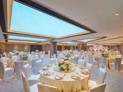 香港香港诺富特世纪酒店的宴会厅配有白色的桌子和白色的椅子