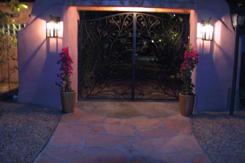 阿尔伯克基Casas de Suenos Old Town Historic Inn, Ascend Hotel Collection的黑色的大门,有两盆植物和两盏灯