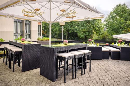 克尔斯特尔巴赫Vienna House Easy by Wyndham Frankfurt Airport的户外桌椅和遮阳伞