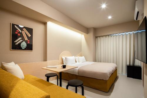 东京Section L Yushima-Ueno的酒店客房配有一张床铺和一张桌子。