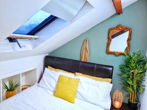 MurtonSafire home的一间卧室配有一张带黄色枕头和镜子的床