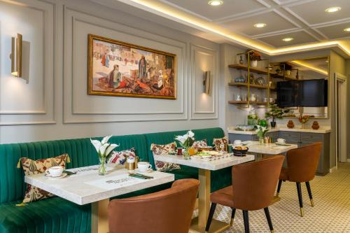 伊斯坦布尔Royan Suites的一间设有两张桌子和绿色座椅的用餐室