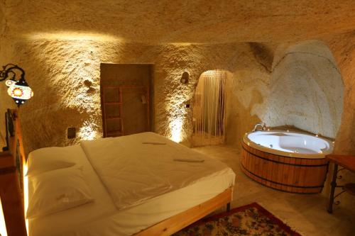阿瓦诺斯Atax Cave House的一间卧室配有一张床和浴缸