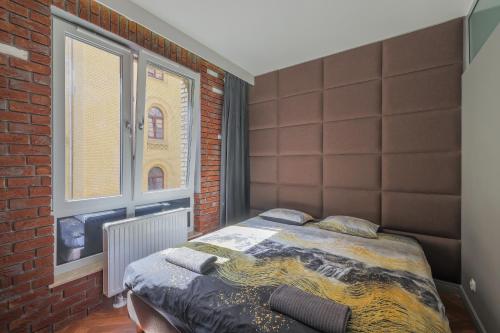 格但斯克Perfect Apartment Oldtown Gdansk的一间卧室设有一张床和砖墙