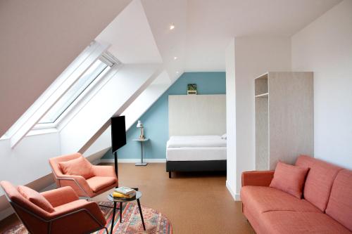 维也纳greet Wien City Nord的客厅配有沙发、两把椅子和一张床