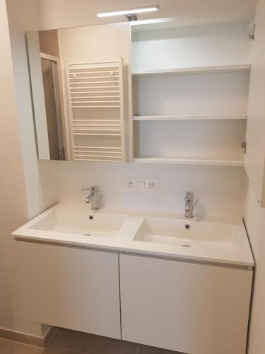 布兰肯贝赫The One - New luxury beachfront apartment的白色的浴室设有两个盥洗盆和镜子