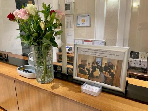 伦敦阿斯特法院酒店的花瓶坐在一张照片的柜台上