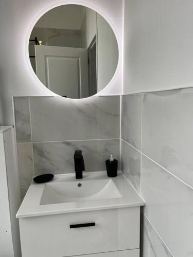莱桑德利La Parenthèse Andelysienne的浴室设有白色水槽和镜子