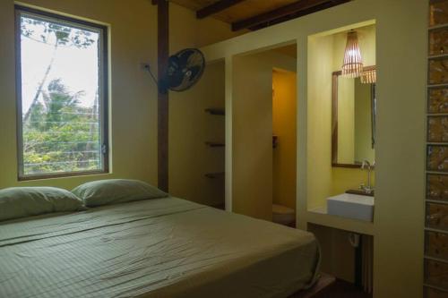 小玉米岛Casa Paraíso - Little Corn Island的一间卧室配有床、水槽和窗户