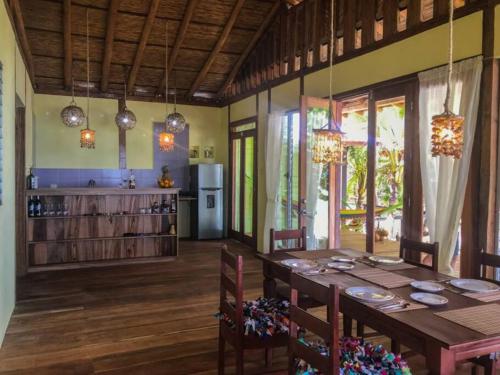 小玉米岛Casa Paraíso - Little Corn Island的一间带桌子的用餐室和一间厨房