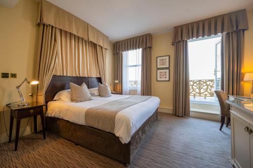 兰迪德诺St George's Hotel - Llandudno的一间卧室设有一张大床和一个大窗户