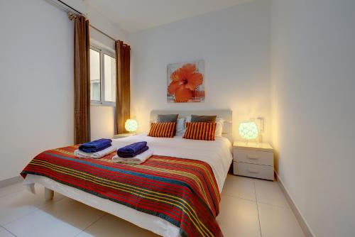 斯利马Modern Apartment steps from Balluta Bay的一间卧室配有一张床,上面有两条毛巾
