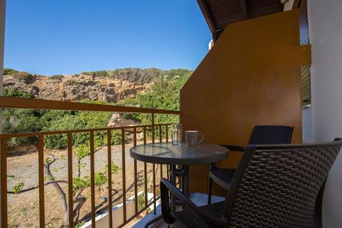 法拉萨纳En Plo Beachfront Rooms的设有一个配有桌椅并享有美景的阳台。