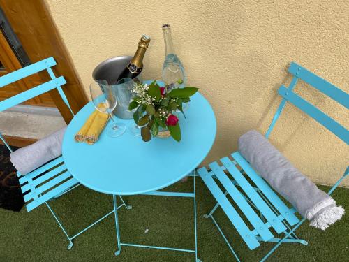 索恩河畔沙隆Le Nid Bourguignon的一张桌子、两把椅子和一瓶葡萄酒及鲜花