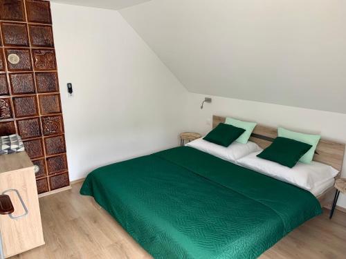 布克福尔多Nono Apartman Bükfürdő的一间卧室配有两张绿色和白色的床