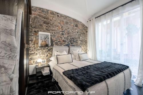 波托菲诺Portofino Luxury Front Marina by PortofinoVip的一间卧室设有一张大床和砖墙